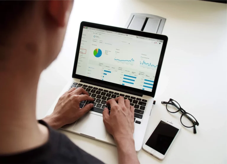 A photo of a man viewing an ascending line chart on his laptop