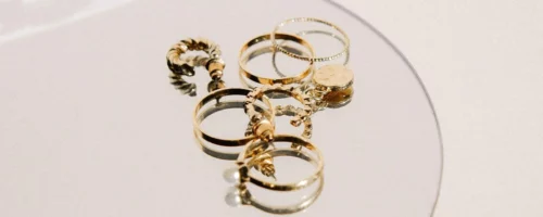 18K gold jewelry items on a glass tray